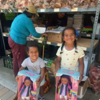 A mother and two children collecting food from the pantry shelves