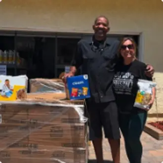 Ida and a volunteer standing in front of a truck loaded with pallets