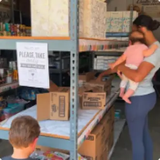 A woman and a small child choosing items from the pantry shelves