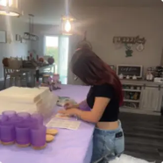 Pouring wax into jars while making candles at home