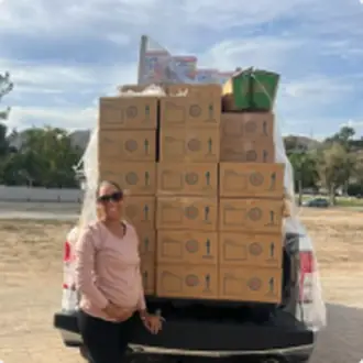 A volunteer with a truckload of boxed food donations